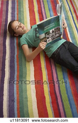 Girl reading a book on the floor View Large Photo Image Stock Image - Girl reading a book on the floor. Fotosearch