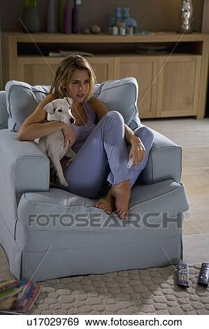 Stock Photo - Woman and dog, sitting, watching tv. Fotosearch