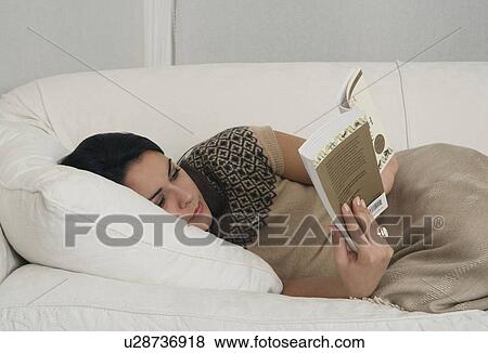 Woman on sofa reading book View Large Photo Image Stock Photo - Woman on sofa reading book. Fotosearch