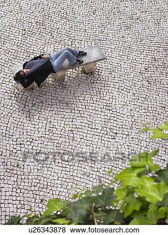 Woman resting on a bench. View Large Photo Image Stock Photo - Woman resting on a bench.. Fotosearch