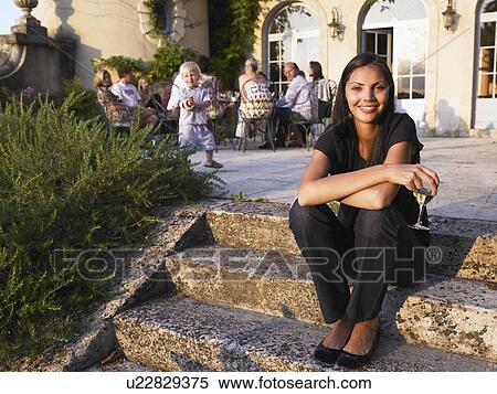 Stock Photography - Woman smiling at a pre-dinner drink. Fotosearch