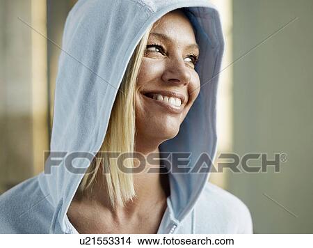 Woman wearing hooded top, smiling, close-up View Large Photo Image Picture - Woman wearing hooded top, smiling, close-up. Fotosearch