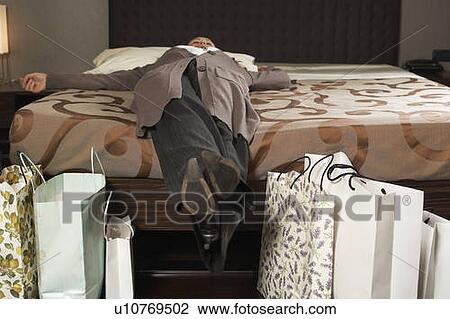 Mature woman on bed with shopping View Large Photo Image Stock Image - Mature woman on bed with shopping. Fotosearch