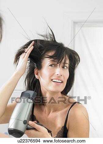 Woman drying her hair View Large Photo Image Picture - Woman drying her hair. Fotosearch