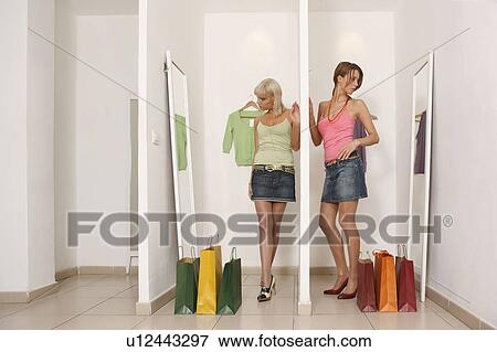 Stock Photo - Young women looking at shop mirrors. Fotosearch