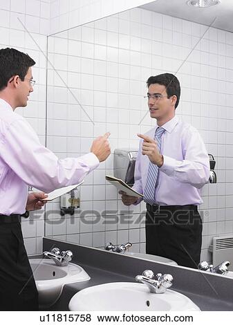 Man practicing speech in office washroom mirror View Large Photo Image Stock Photo - Man practicing speech in office washroom mirror. Fotosearch