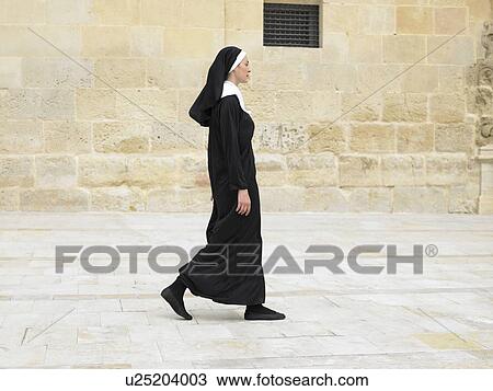 Nun walking in front of stone wall, Alicante, Spain, View Large Photo Image Stock Image - Nun walking in front of stone wall, Alicante, Spain,. Fotosearch