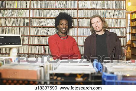 Two men in music shop, smiling, portrait View Large Photo Image Stock Image - Two men in music shop, smiling, portrait. Fotosearch