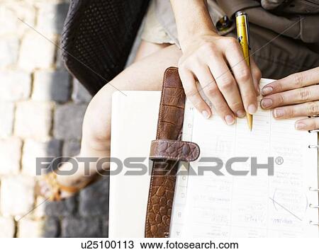 Stock Image - Woman sitting outdoors. Fotosearch
