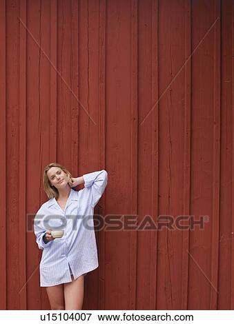 Woman with mug standing in front of red wall smiling. View Large Photo Image Stock Photo - Woman with mug standing in front of red wall smiling.. Fotosearch