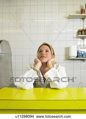 Young woman resting elbows on counter in fish and chip shop View Large Photo Image Picture - Young woman resting elbows on counter in fish and chip shop. Fotosearch