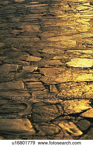 Stock Photo -  a Cobbled Road, Some Light Partly Shining at It, High Angle View. Fotosearch