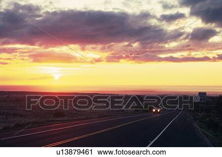 Stock Image -  a Country Road By Sunset, a Carpet of Clouds Spreading Over the Land. Fotosearch