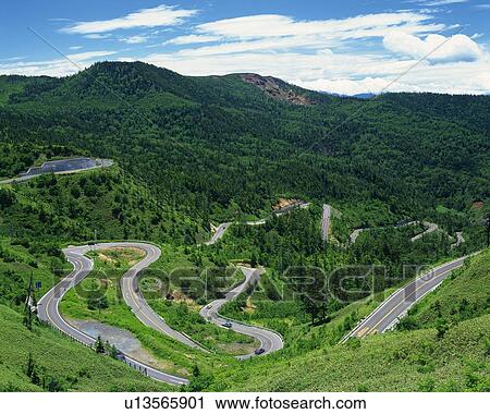 Stock Image -  a Curvy Country Road Among Several Mountains, High Angle View. Fotosearch