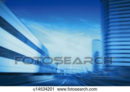Stock Image -  a Highway Among Some Buildings, Front View, Blurred Motion, Toned Image. Fotosearch