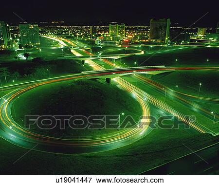 Stock Photo -  a Highway With Multi-lanes and Several Curves at Night, Surrounded By an Illuminated City, High Angle View, Brazil, South America, Long Exposure. Fotosearch