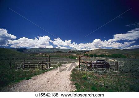 Stock Photo -  a Little Ranch With a Wooden Fence Under a Blue Sky. Fotosearch