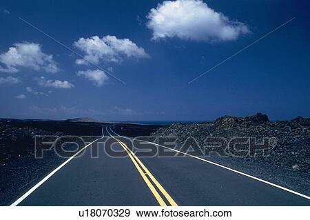 Stock Photo -  a Long Country Road Under a Blue Sky, Front View. Fotosearch
