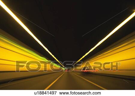 Stock Photo -  a Tunnel With Several Lights and Cars In it, Front View, Long Exposure, Blurred Motion. Fotosearch