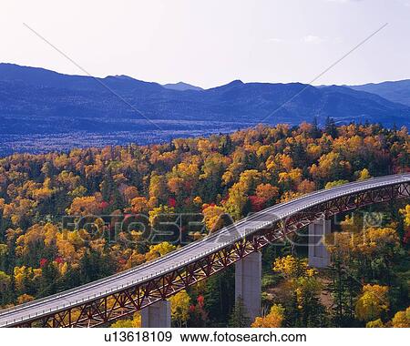 Stock Photo -  the Mikuni-toge Pass Highway, Surrounded By Autumn-colored Trees and Some Mountains, High Angle View, Hokkaido Prefecture, Japan. Fotosearch