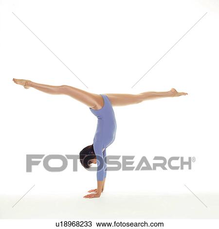 Stock Image - A woman in Leotard doing handstand, Side View, Copy Space. Fotosearch