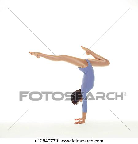 Stock Photo - A woman in Leotard doing handstand, Side View, Copy Space. Fotosearch