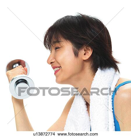 Picture - A woman in Leotard exercising with a dumbbell, Side View. Fotosearch