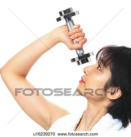 Stock Image - A woman in Leotard exercising with a dumbbell, Side View. Fotosearch