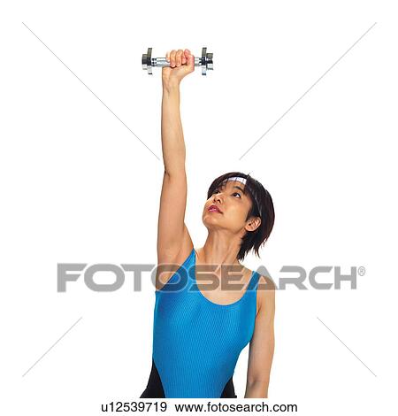 Stock Photo - A woman in Leotard exercising with a dumbbell, Front View, Copy Space. Fotosearch