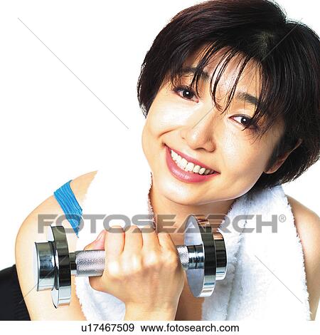 Stock Photo - A woman in Leotard exercising with a dumbbell, Front View. Fotosearch