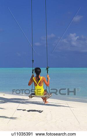 a Woman Wearing a Bathing Suit, Swinging, Looking at the Clear Ocean, Rear View, Maldives, Micronesia View Large Photo Image Stock Image - a Woman Wearing a Bathing Suit, Swinging, Looking at the Clear Ocean, Rear View, Maldives, Micronesia. Fotosearch