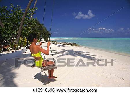 a Woman Wearing a Bathing Suit, Swinging, Looking at the Clear Ocean, Side View, Maldives, Micronesia View Large Photo Image Stock Photograph - a Woman Wearing a Bathing Suit, Swinging, Looking at the Clear Ocean, Side View, Maldives, Micronesia. Fotosearch
