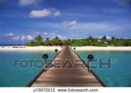 Stock Image -  a Wooden Boardwalk Heading to the Island, Surrounded By Clear Ocean water, Front View, Maldives, Micronesia. Fotosearch