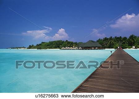 Stock Image -  a Wooden Boardwalk Heading to the Island, Surrounded By Clear Ocean water, Maldives, Micronesia. Fotosearch