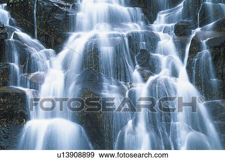 Stock Photo -  a Waterfall, Surrounded By Several Rocks, Low Angle View, Long Exposure, Akita Prefecture, Japan. Fotosearch