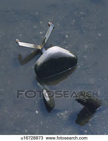 Stock Image - Chair abandoned in river. Fotosearch