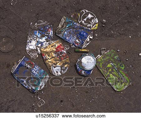 Stock Photo - Crushed aluminum cans in mud, high angle view. Fotosearch