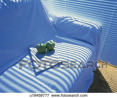Stock Photo - Apples and newspaper on a sofa, High Angle View. Fotosearch