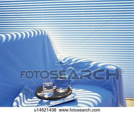 Stock Photo - Glass and pitcher on the sofa, High Angle View. Fotosearch