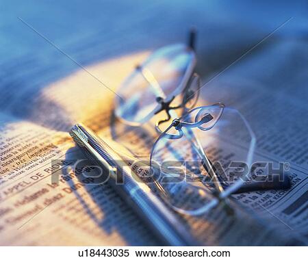 Stock Photography - Glasses and pen on newspaper, Close Up, High Angle View, Differential Focus. Fotosearch