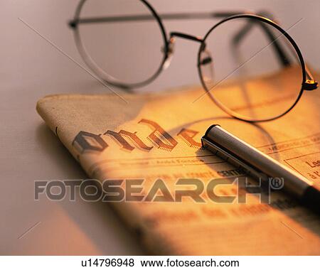 Stock Photo - Glasses and pen on the newspaper, Close Up, High Angle View, Differential Focus. Fotosearch