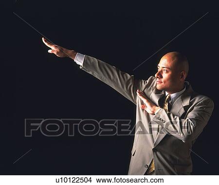 Picture - A bald headed businessman posing, Side View. Fotosearch