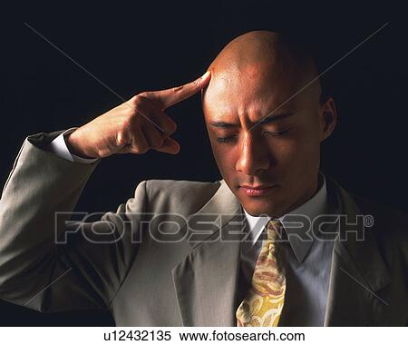 Stock Photography - A bald headed businessman thinking with finger put on head, Front View. Fotosearch