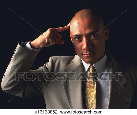 A bald headed businessman touching head with index finger, Front View View Large Photo Image Stock Image - A bald headed businessman touching head with index finger, Front View. Fotosearch