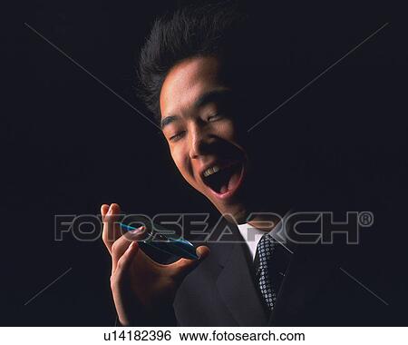 Stock Photograph - A businessman holding a CD and smiling, Low Angle View. Fotosearch