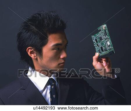 A businessman holding an electrical device, Side View View Large Photo Image Stock Image - A businessman holding an electrical device, Side View. Fotosearch