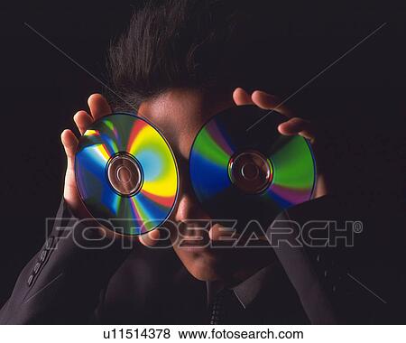 A businessman holding two CD-Rs by his eyes, Front View View Large Photo Image Stock Photo - A businessman holding two CD-Rs by his eyes, Front View. Fotosearch