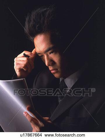 A businessman looking at a file and thinking, Side View View Large Photo Image Picture - A businessman looking at a file and thinking, Side View. Fotosearch