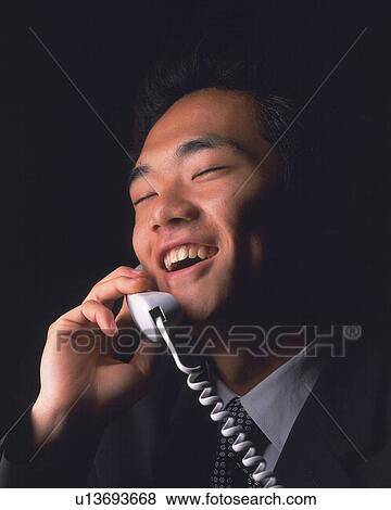 Stock Photo - A businessman talking on the phone, Side View. Fotosearch