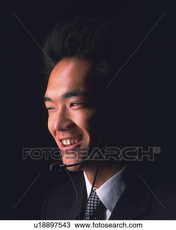 A businessman with a headset smiling, Side View View Large Photo Image Stock Image - A businessman with a headset smiling, Side View. Fotosearch